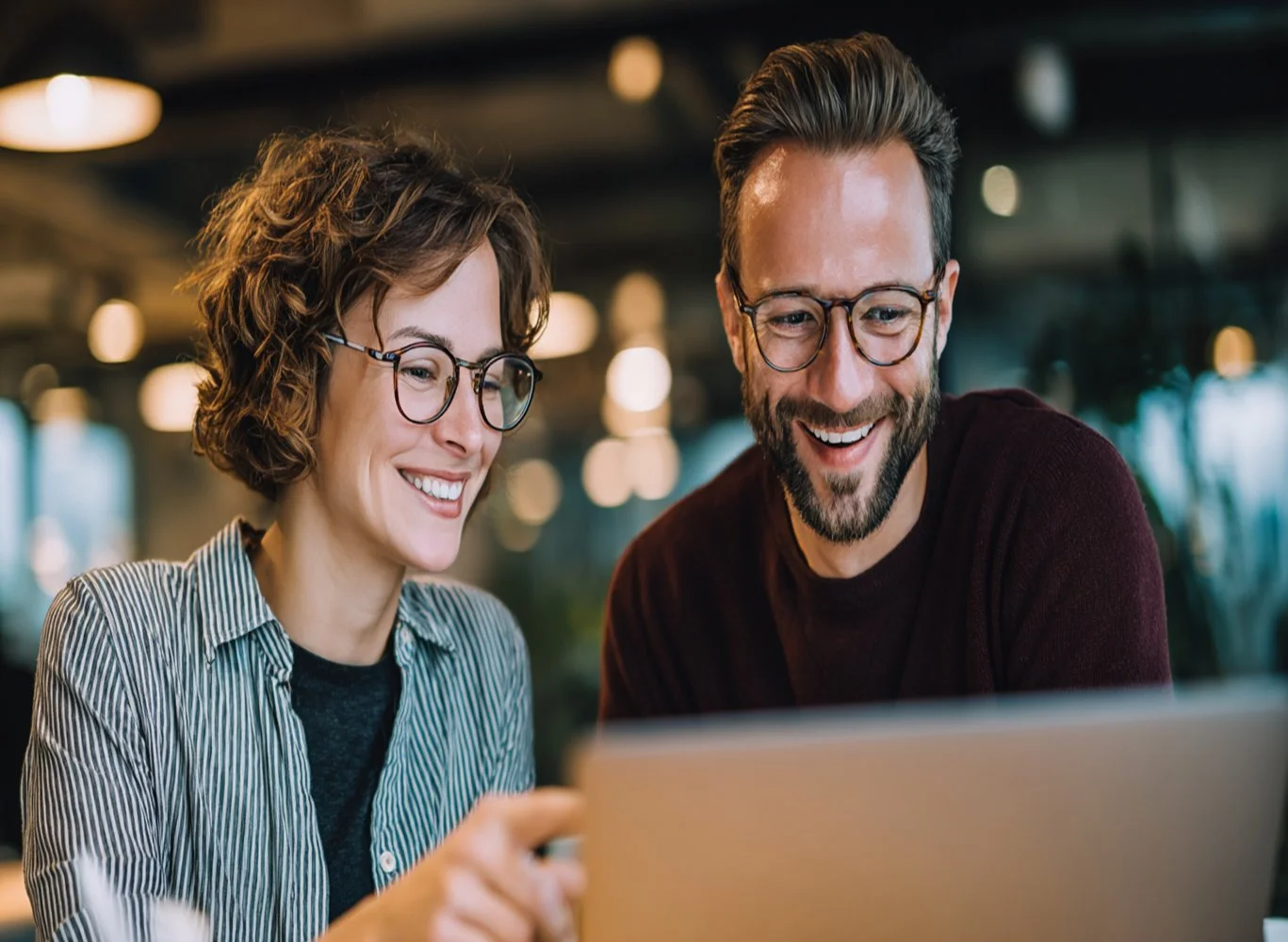 Happy couple reviewing their Bear Loan personal loan approval on a laptop together